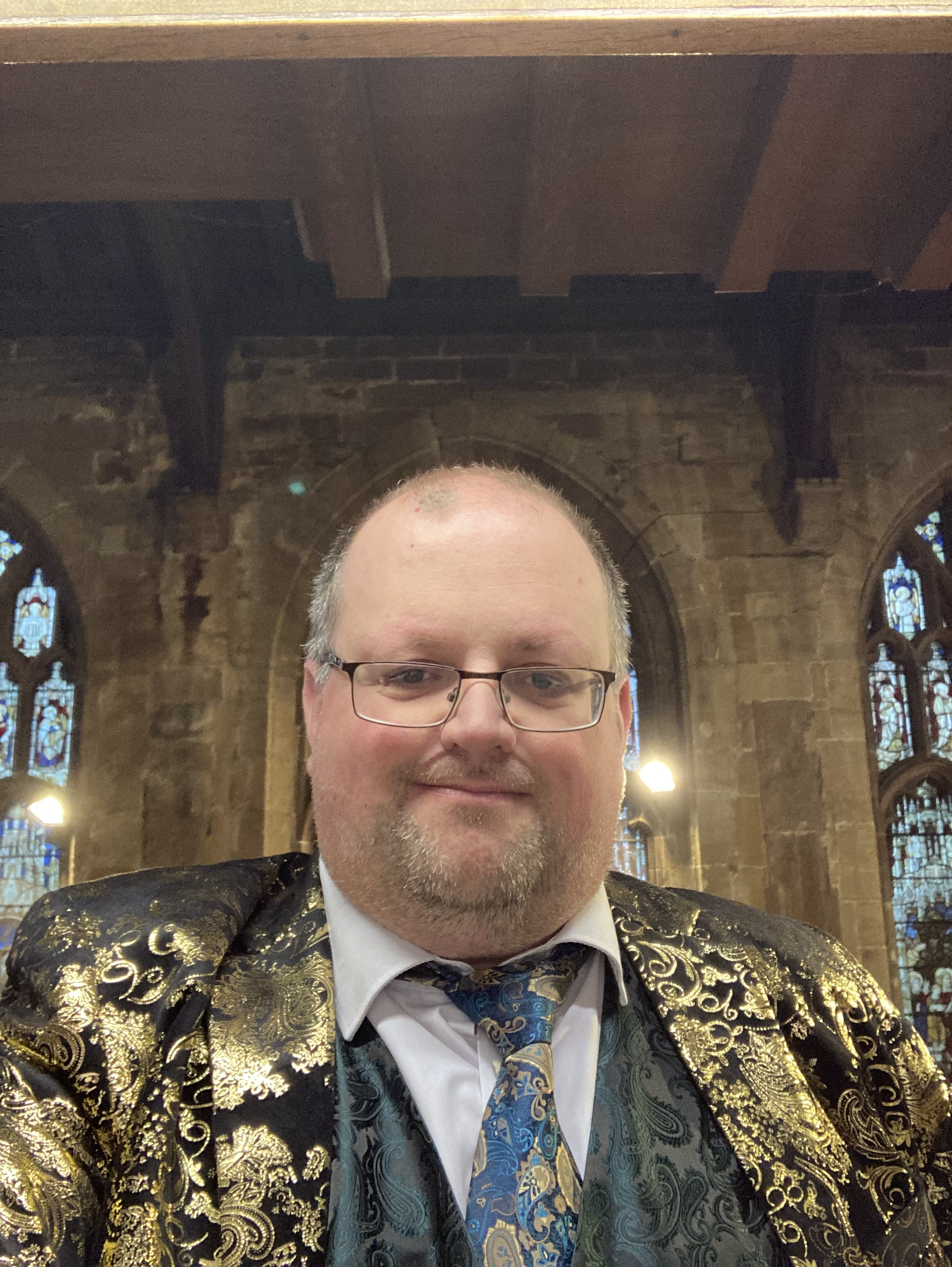 Andrew Clayton in a gold jacket, green waistcoat and clashing tie.